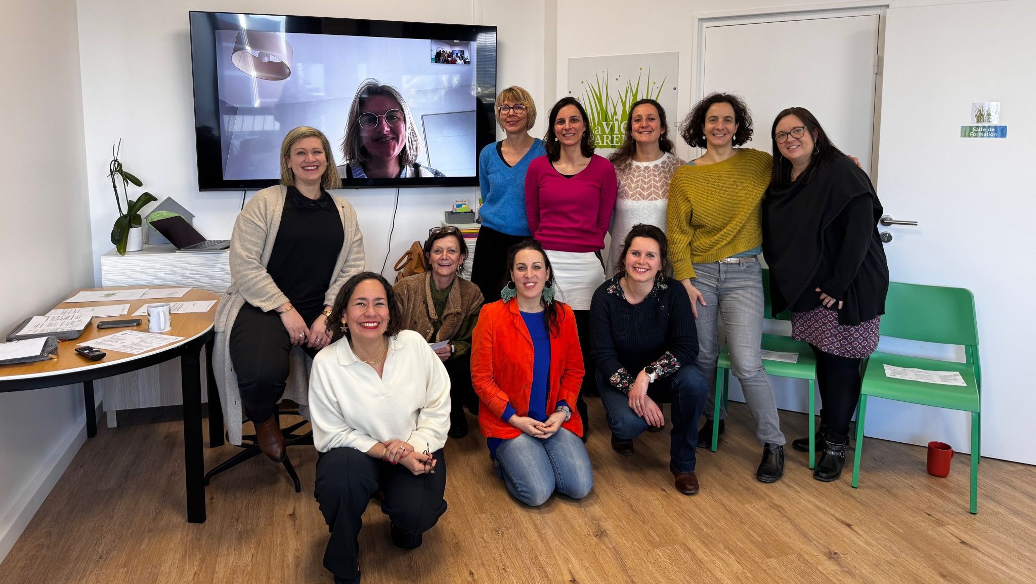 Celine Dahan se tient debout de profil dans une pièce avec un un micro dans sa main droite, qu'elle porte auprès de sa bouche.